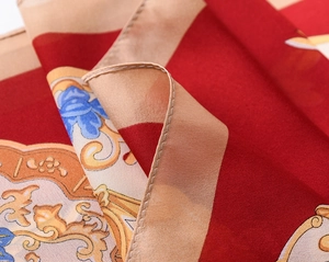 Detailed view of dark red baroque floral pattern on glossy silk-like scarf fabric
