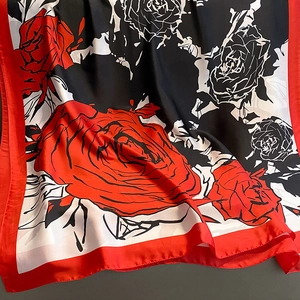 Detail of red and black rose floral print silk scarf with smooth satin sheen finish