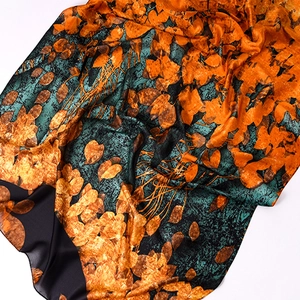 Artistic leaf print silk scarf in orange and turquoise with glossy texture finish