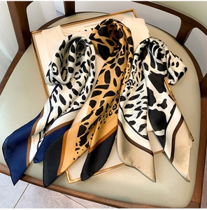 Macro detail of silk leopard print scarves in navy and brown on a white shirt