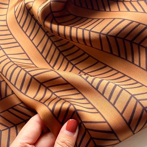 Macro shot of tie-dye geometric pattern on silk-feel scarf with elegant caramel brown texture