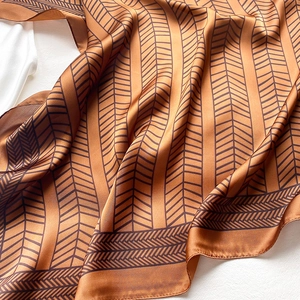Detailed view of bronze faux silk scarf with geometric herringbone pattern texture