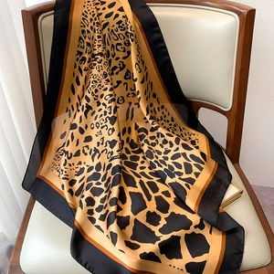 Detailed texture of silk leopard print scarf draped over a chair with geometric pattern