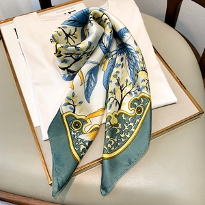 Floral satin scarf featuring artistic blue and yellow patterns draped on a white shirt