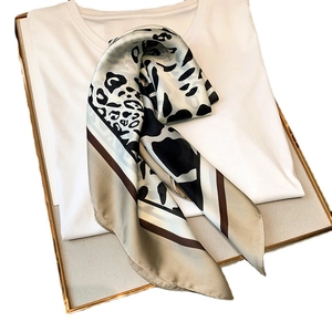 Leopard print silk scarf on white shirt background with minimalist gold frame accent