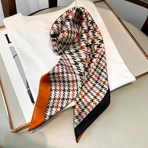Écharpe longue en soie à motif pied-de-poule et bords orange sur un t-shirt blanc propre