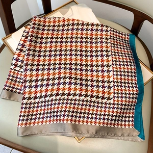 Détail d'un foulard en soie à motif pied-de-poule coloré avec bordure en satin