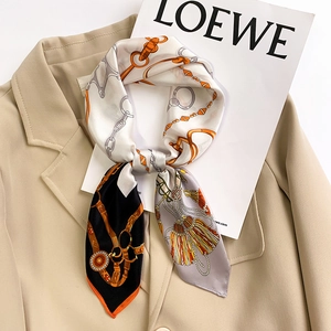 Carré de soie aux motifs de chaînes orange et noires avec des glands élégants