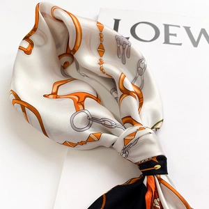 Gros plan d'un foulard en soie élégant avec motifs de chaînes et mors équestres