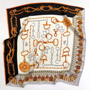 Détail du motif de chaîne équestre et du mors doré sur le foulard en soie véritable