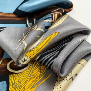 Gros plan d'un foulard en soie montrant des motifs de corde vintage et un motif d'oiseau