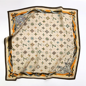 Détail d'un foulard carré en soie présentant des chaînes et des motifs de plumes