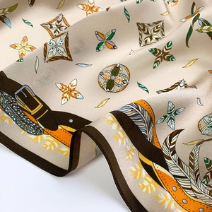 Gros plan détaillé du foulard en soie champagne aux motifs de chaîne de style équestre