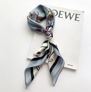 Détail d'un foulard en soie bleu avec motif équestre vintage et cavaliers