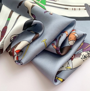 Détail macro du foulard en soie avec imprimés de polo équestre et texture satinée