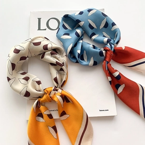 Détail d'un élégant foulard en soie avec motif de chapeau vintage et fini satin