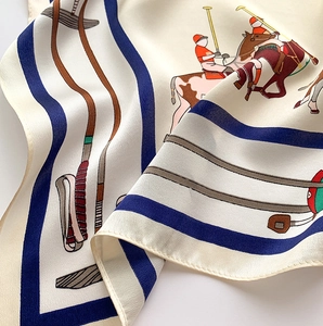 Gros plan d'un foulard en soie à motif polo montrant la texture et l'ourlet délicat