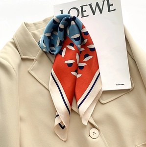 Élégant carré en soie au motif chapeau rouge et bleu sur un col de blazer beige