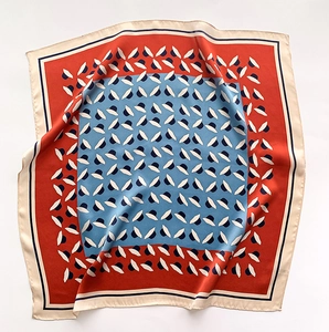 Détail d'un carré de soie rouge et bleu avec motifs de chapeaux géométriques