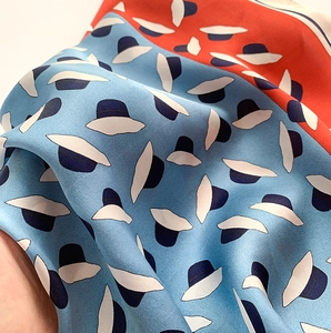 Gros plan d'un foulard en soie avec motifs chapeaux bleus et bord roulé délicat