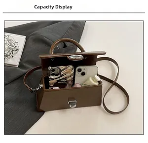 Vue de la capacité intérieure du sac boîte marron avec deux smartphones et crème