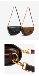 Detail of saddle bags in black and brown featuring a unique wavy flap and gold chain