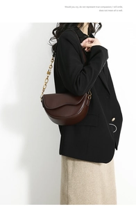 Brown faux leather saddle bag with gold chain strap shown on black blazer outfit