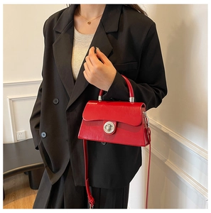 Détail du sac à main rouge avec fermoir métallique argenté et bandoulière amovible