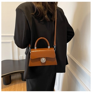 Sacoche vintage en cuir marron avec fermoir argenté porté avec un blazer noir oversize