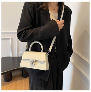 Sac à bandoulière minimaliste en cuir blanc crème avec élégant fermoir rond argenté