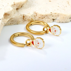 Festive gold hoop earrings with enamel Santa Claus charms on a white textured background