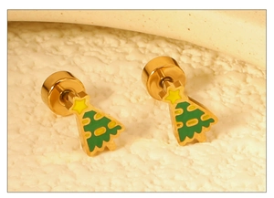 Détail macro de boucles d'oreilles sapin de Noël en émail vert et finition dorée sur pierre