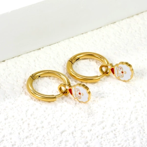 Festive gold hoop earrings with red and white enamel Santa Claus charms on stone surface