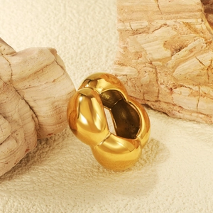 Polished 18K gold minimalist geometric ring displayed on elegant stone pedestals