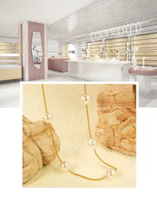 Detailed view of a gold bead chain necklace featuring five lustrous round white pearls