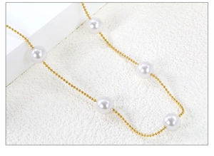 Macro shot of large round white pearl on a gold-plated metal chain with high luster