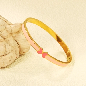 Minimalist gold plated bangle with pink enamel coating and butterfly heart center