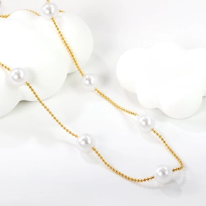 Elegant gold bead necklace with six white pearls displayed on cloud-shaped stands