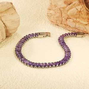 Silbernes Tennisarmband mit rechteckigen lila Zirkonia auf texturiertem Stein-Hintergrund