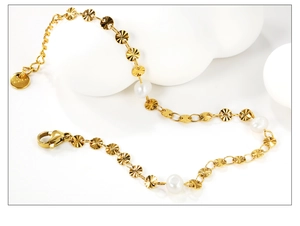 Détail d'un bracelet en acier inoxydable doré avec perles et disques métalliques gravés