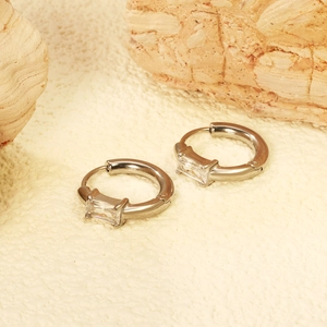 Eleganti orecchini a cerchio argento con zircone rettangolare su sfondo in pietra