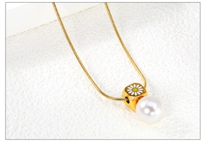 Gros plan détaillé d'un pendentif doré avec motif marguerite et une perle de haute brillance