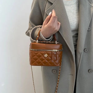 Elegant brown quilted bucket bag with gold flower detail and chain strap for women