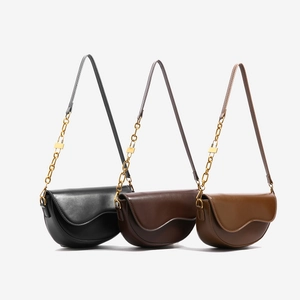 Three minimalist saddle bags in black, dark coffee and light brown with golden chain straps