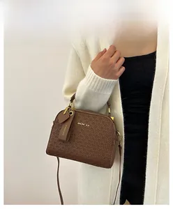 Detail of dark brown shell bag with woven texture and gold dual zipper closures