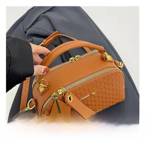 Close-up of brown textured woven leather handbag with dual gold zippers and sturdy handle