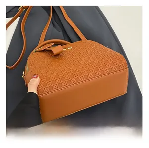 Detailed view of woven leather texture and smooth paneling on the orange crossbody bag