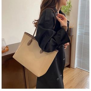 Chic beige tote bag with dark brown trim shown in a stylish minimalist interior setting