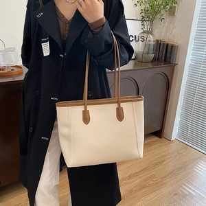 Large beige leather tote bag with brown handles, perfect for office and daily commuting