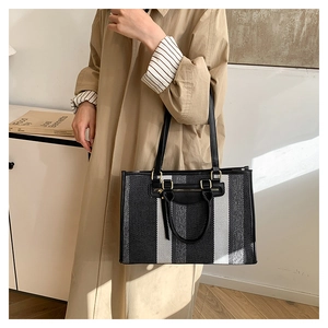 Fashionable large capacity woven tote bag with stripe pattern shown in life style context